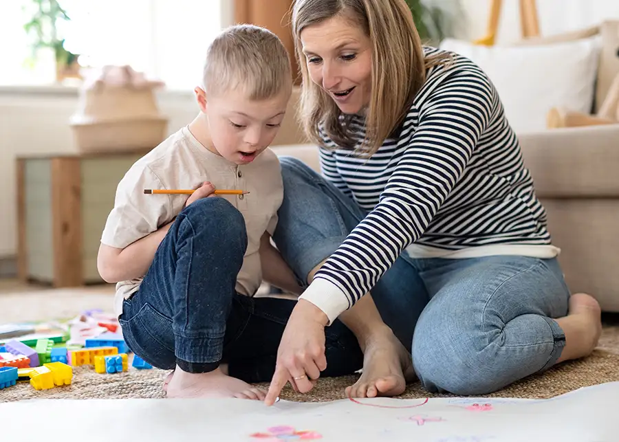 Adoption Subsidy - mother with adopted son - son with downs-syndrome playing together - child with special needs - Springfield, IL