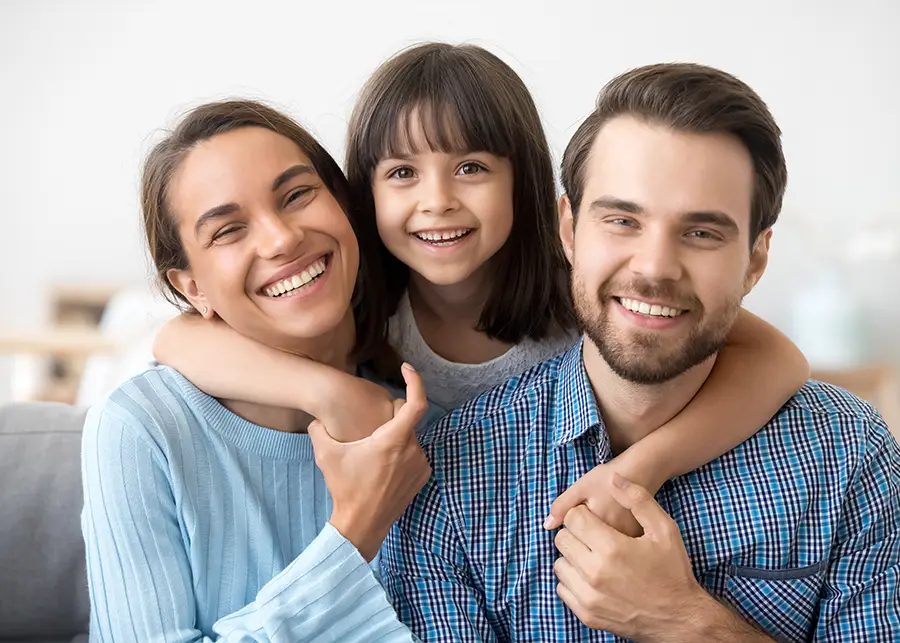Adoption - Young girl with her arms around a husband and wife who just adopted her. - Decatur, IL