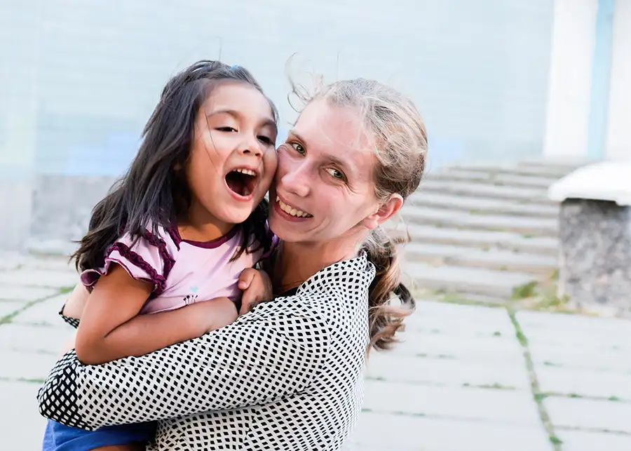 International Adoption - mother cuddling adopted daughter of Asian decent - Asian daughter - adoption - bloomington il