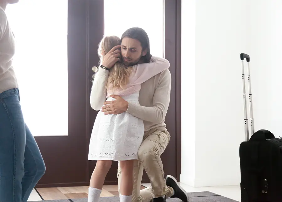 Abuse and Neglect Investigation - Young dad hugging daughter with a suitcase next to her leaving due to a DCFS administrative appeal. bloomington il