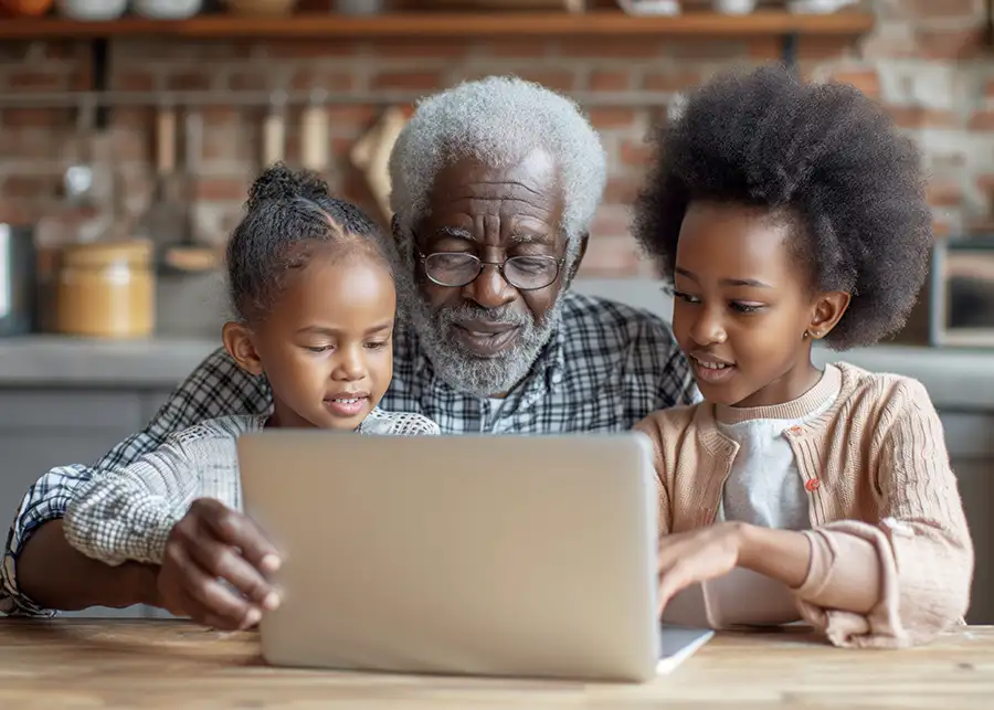 Grandfather with his two granddaughters looking at computer - grandpa now has custody of his grandkids - Relative Placements in DCFS Cases - bloomington il